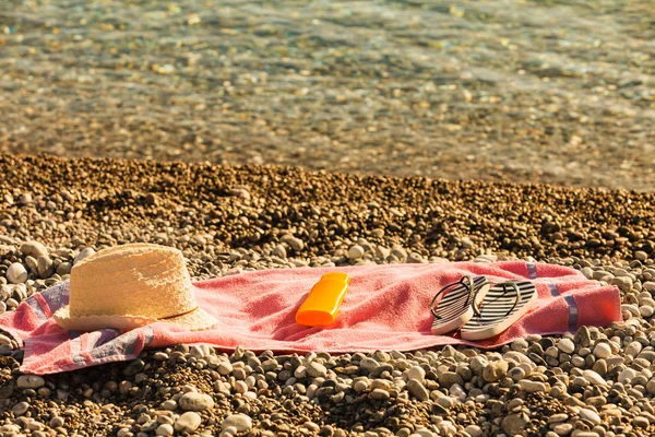 Zonnehoed en flip flops op Stone Beach — Stockfoto