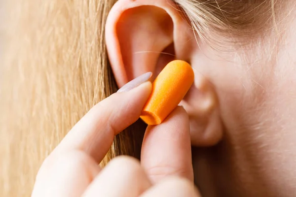 Woman putting earplugs Stock Photo