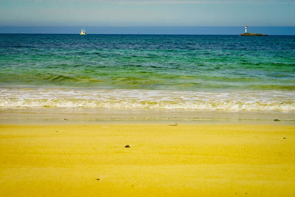 Sandstrand mit Leuchtturm am Horizont — Stockfoto