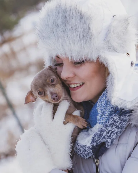 Mulher brincando com cão durante o inverno — Fotografia de Stock