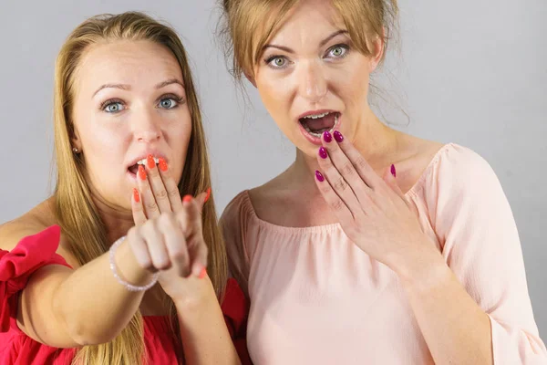 Duas jovens mulheres que parecem chocadas — Fotografia de Stock