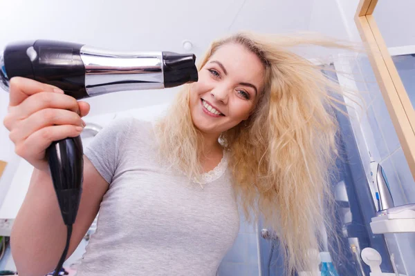 Frau trocknet Haare im Badezimmer — Stockfoto