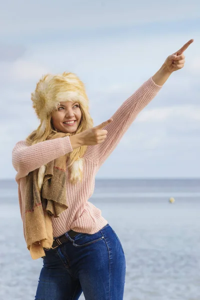 Fashionable woman on beach pointing — Stock Photo, Image