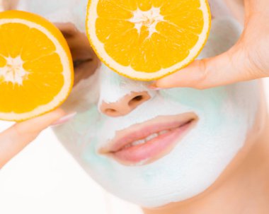 Yüzünde kız çamur maskesi turuncu meyve tutar