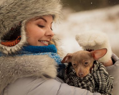 Küçük köpeğini kışın ısınma kadın kucaklama