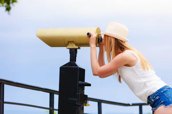 Mulher turista com chapéu de sol olhando através do telescópio — Fotografia de Stock