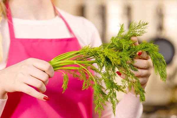 Woman holding green dill herb