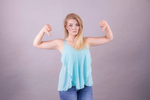 Mujer triste mostrando el pulgar hacia abajo gesto — Foto de Stock