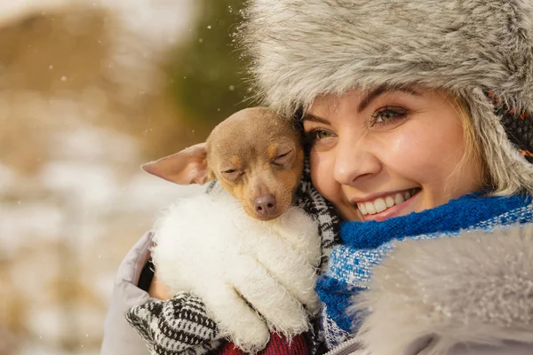 Mujer abrazo calentando su pequeño perro en invierno —  Fotos de Stock