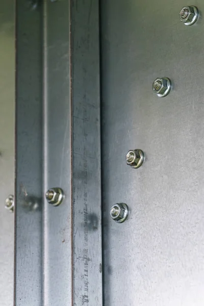 Schraubkappen an einer Stahlwand aus Metall. — Stockfoto