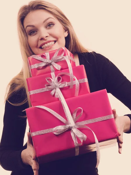Девушка держит стопку розовых подарочных коробок — стоковое фото