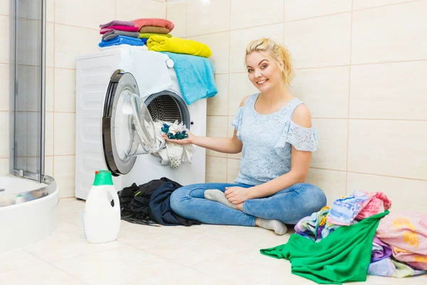 Woman wash laundry using detergent pods
