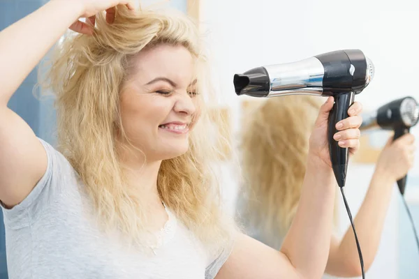Mujer rubia usando secador de pelo — Foto de Stock