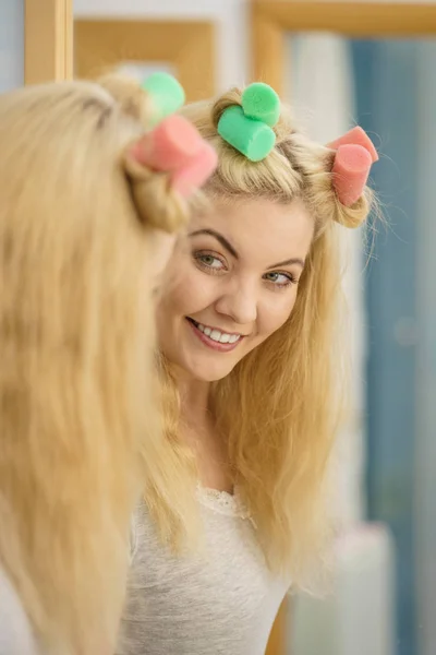 Blonde woman using hair rollers — Stock Photo, Image