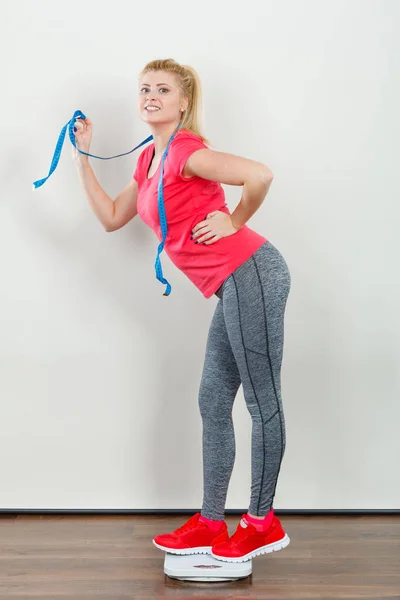Woman wearing sportswear standing on weight machine — Stock Photo, Image