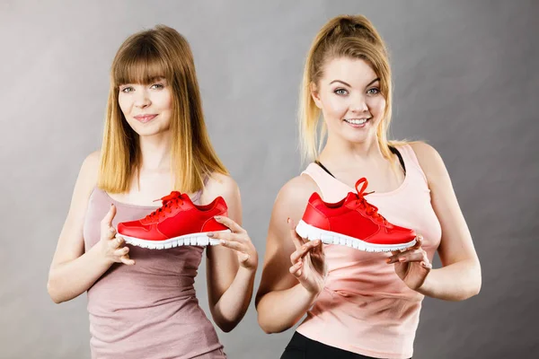 Zwei Frauen präsentieren Sportbekleidung Turnschuhe — Stockfoto