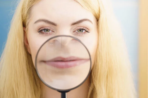 Vrouw met behulp van magnifer op haar lippen — Stockfoto