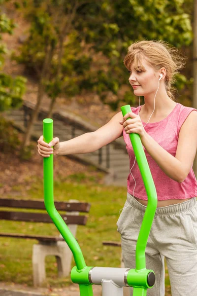 Mujer activa haciendo ejercicio sobre un entrenador elíptico . — Foto de Stock