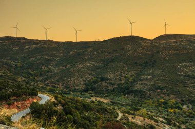 dağlarda gün batımında rüzgar türbinleri çiftlik