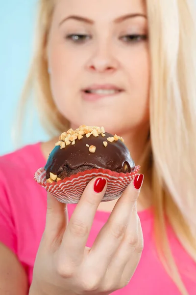 Woman holding chocolate cupcake about to bite Royalty Free Stock Images