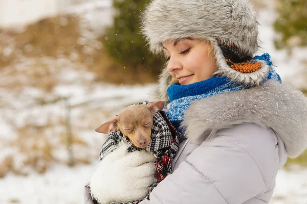 Mujer abrazo calentando su pequeño perro en invierno —  Fotos de Stock