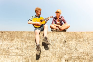Genç kadın için gitar çalmak hipster adam.