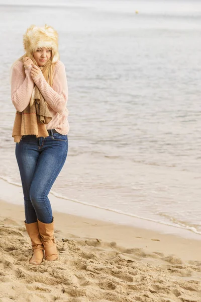 Женщина в стильном наряде чувствует холод у моря — стоковое фото