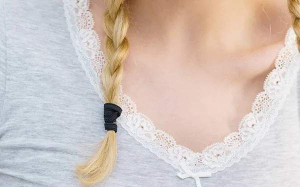 Vrouw maken vlecht op blonde haren — Stockfoto