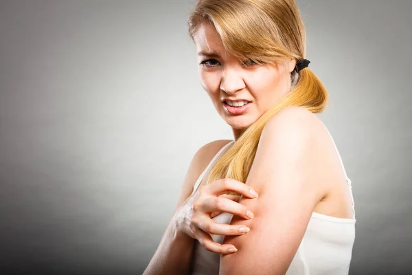 Frau kratzt sich mit allergischem Ausschlag am juckenden Arm — Stockfoto