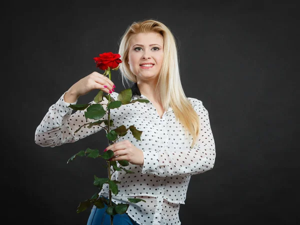 Woman holding rose flower on black