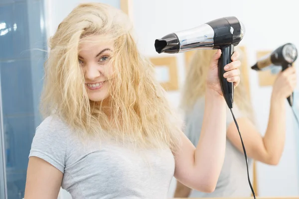 Mulher loira usando secador de cabelo — Fotografia de Stock