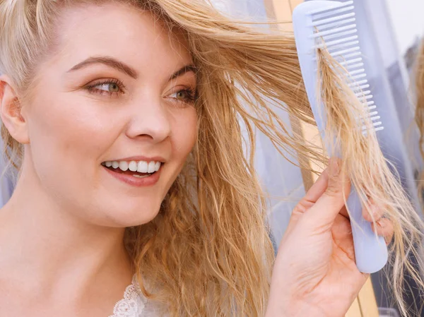 Mujer peinando su pelo largo en el baño — Foto de Stock