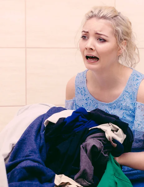 Ongelukkig meisje sorteren vuile kleren Wasserij. — Stockfoto