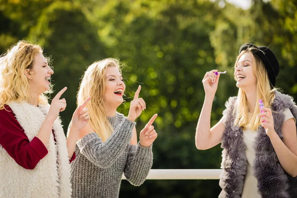 Femmes amis soufflant des bulles de savon . — Photo