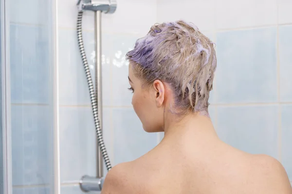 Mulher sob o chuveiro com espuma colorida no cabelo — Fotografia de Stock