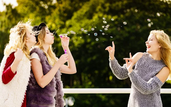 Mulheres soprando bolhas de sabão, se divertindo — Fotografia de Stock