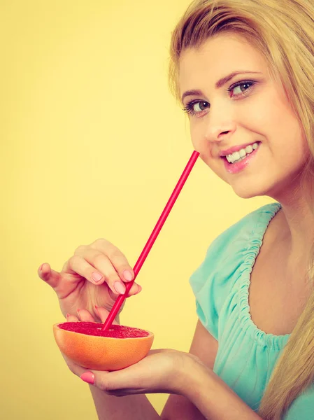 Kvinna som dricker juice från frukt, röd grapefrukt — Stockfoto