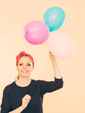 Balonlarla eğleniyor gülümseyen çılgın kız.
