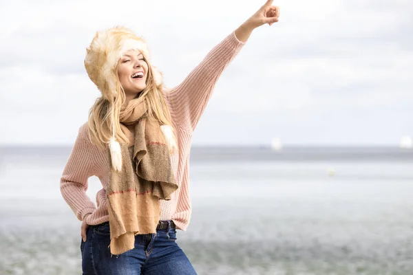 Femme à la mode sur la plage pointant — Photo