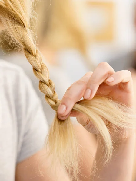 Mulher fazendo trança no cabelo loiro — Fotografia de Stock