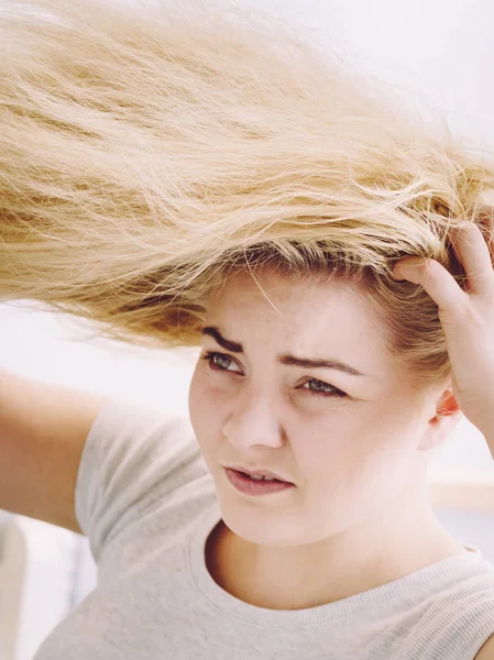 Mujer teniendo problemas con el cabello rubio —  Fotos de Stock