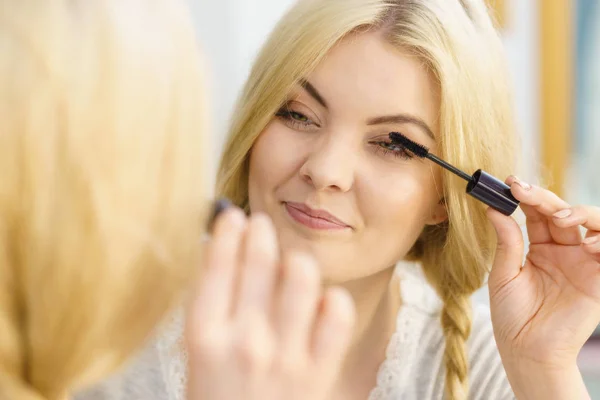 Vrouw met behulp van mascara op haar wimpers — Stockfoto