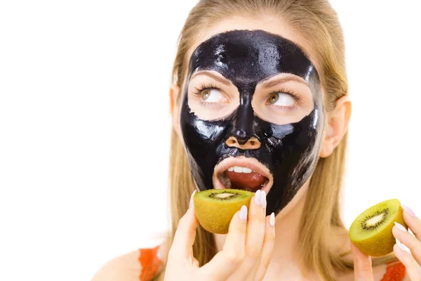 Girl black mask on face holds kiwi fruit — Stock Photo, Image