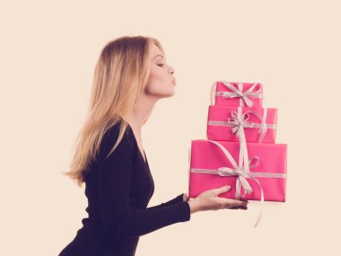 Pembe hediye kutuları yığını tutan kız