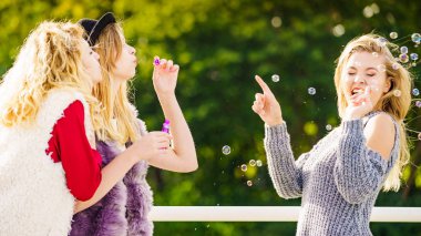 Sabun kabarcıkları üfleyen kadınlar, eğleniyorlar