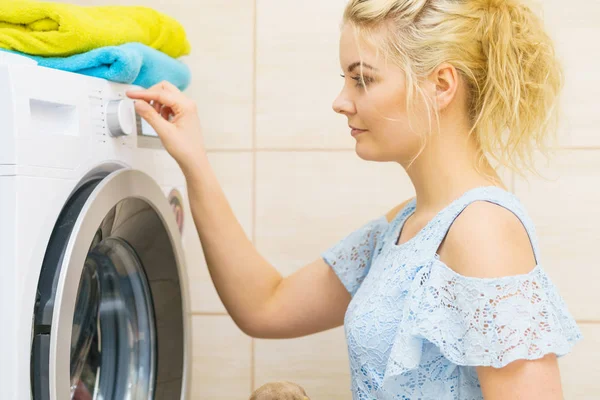 Mulher configuração máquina de lavar roupa — Fotografia de Stock