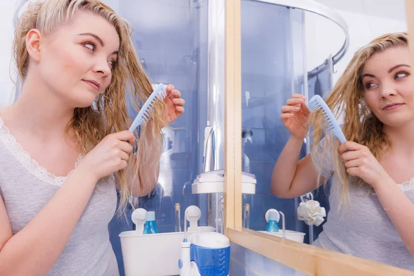 Donna pettinando i capelli lunghi in bagno — Foto Stock