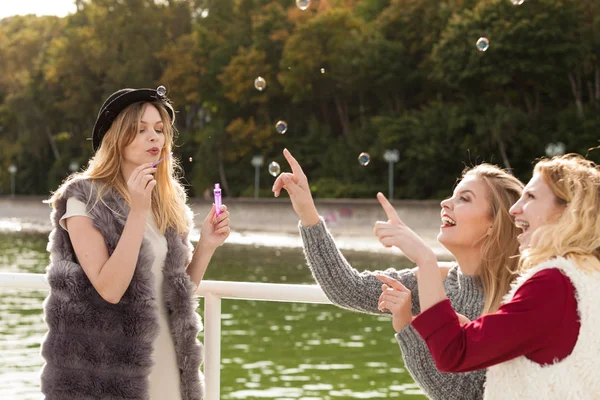 Mulheres brincando juntas soprando bolhas de sabão — Fotografia de Stock