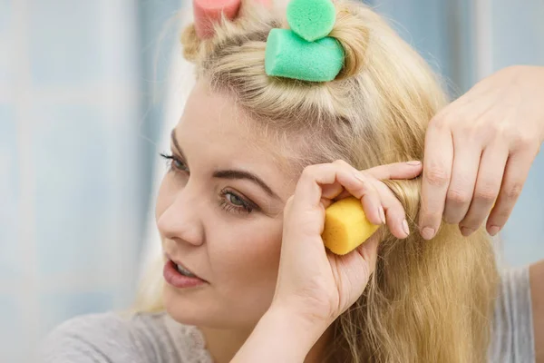 Blondine benutzt Haarwalzen — Stockfoto