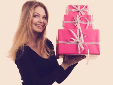 Pembe hediye kutuları yığını tutan kız